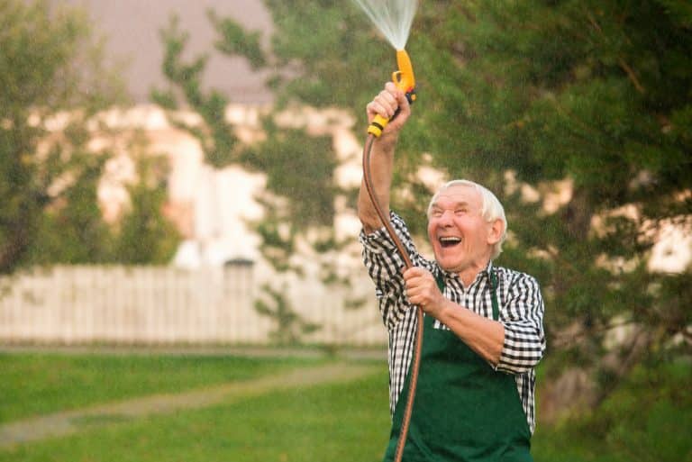 Senior gardener with water hose