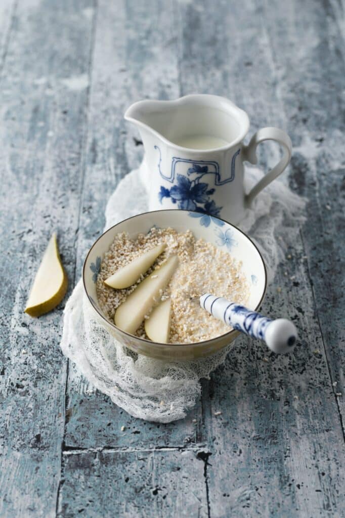 Schale mit gepufftem Amaranth, Birnenscheiben und einem Milchkännchen