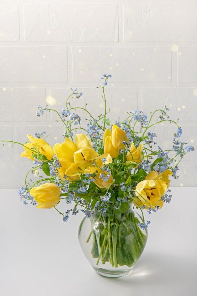 Kytice žlutých tulipánů a modrých květin