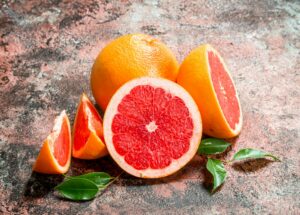grapefruit - rozkrájený na půlky a čtvrtky s lístkami okolo